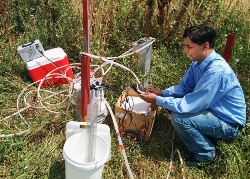 Dr. Babur Mirza takes a groundwater sample from a well in Logan, Utah. 